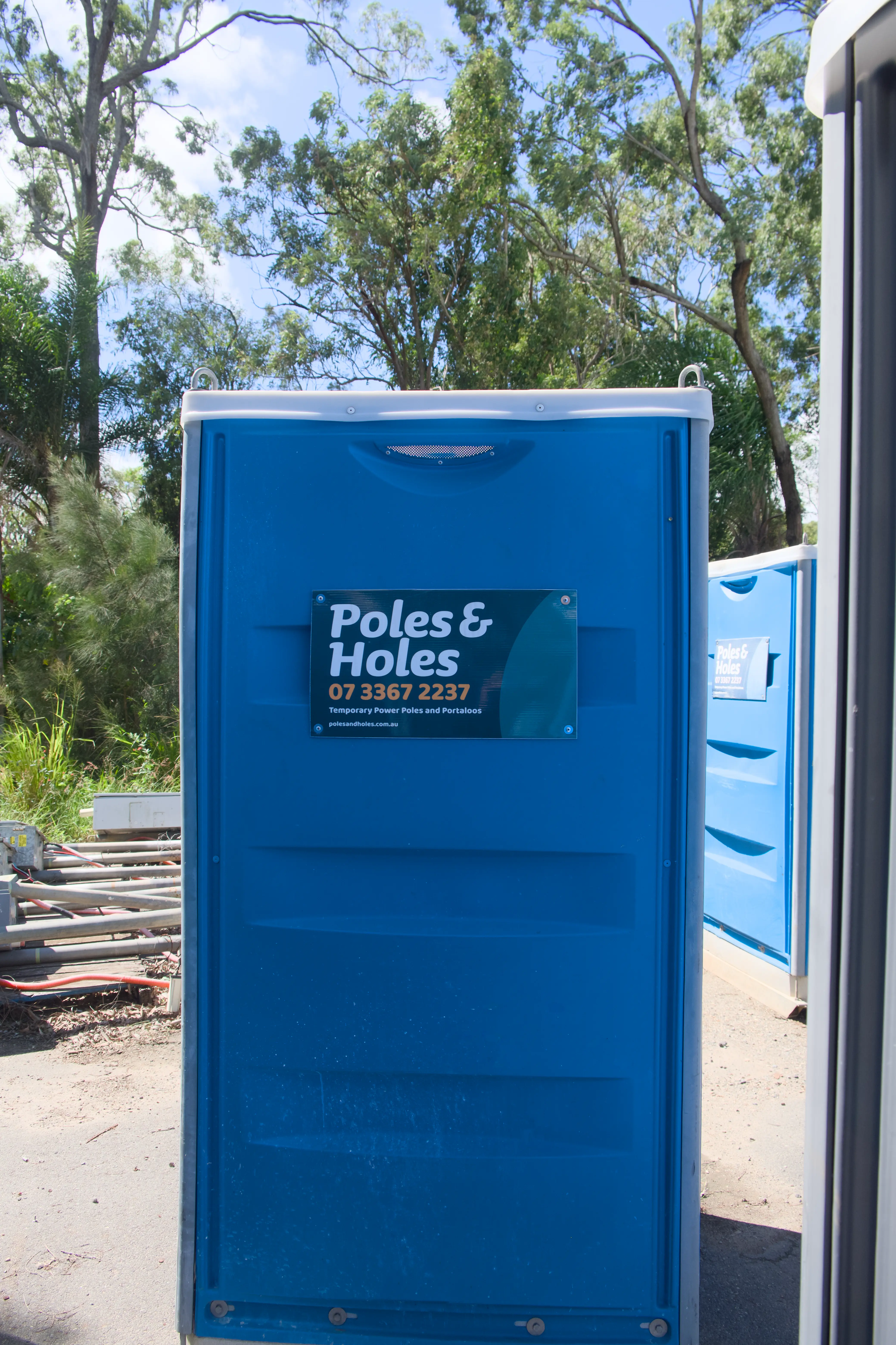 Front view of a Poles and Holes portable toilet