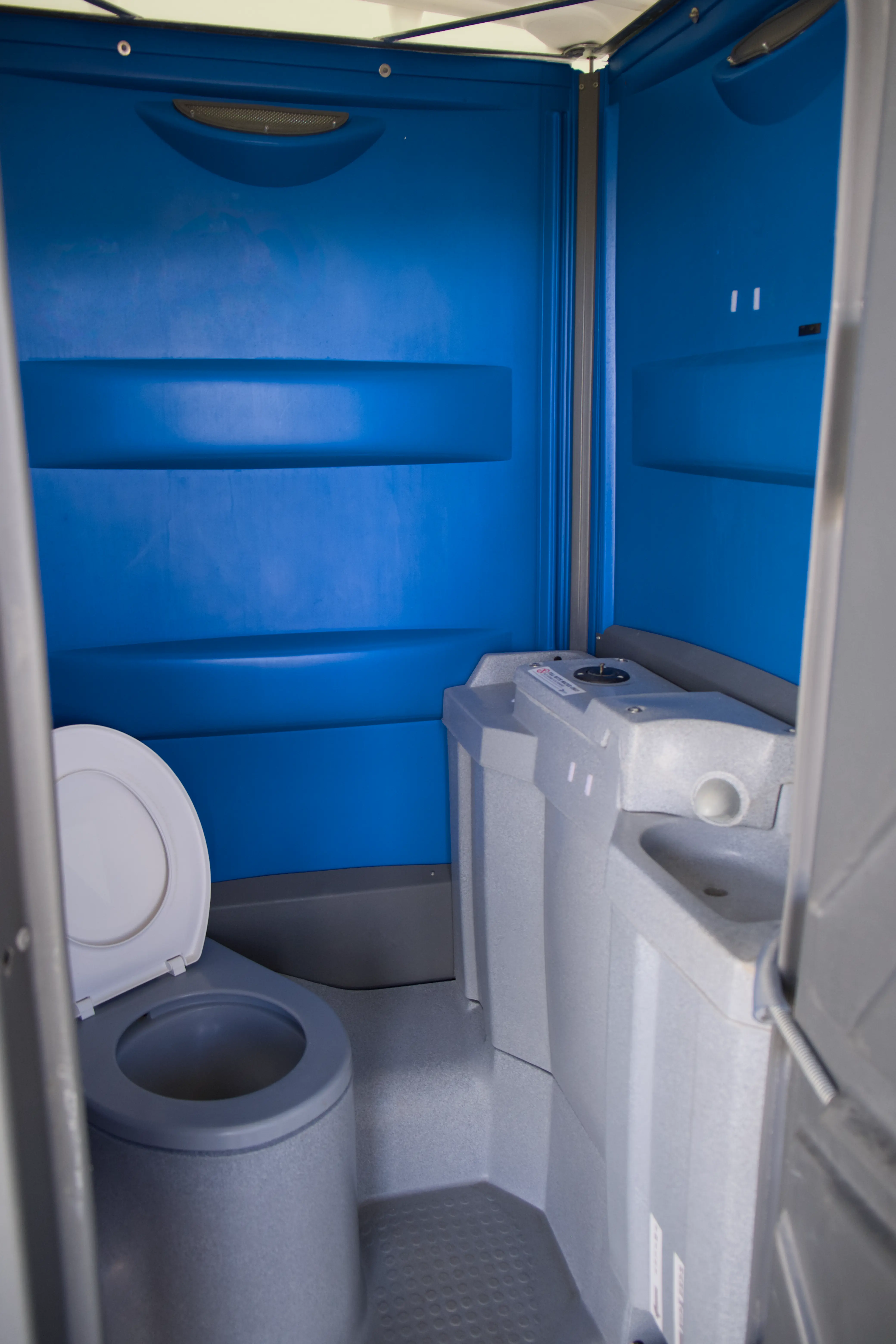 Clean interior of a Poles and Holes portaloo with fresh water flush