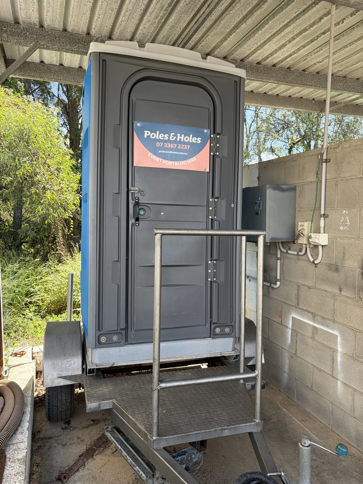 Trailer-mounted portable toilet with access step, set up on a South East Queensland site