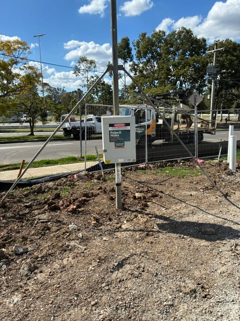 A Poles and Holes temporary builder's power pole installed with metal stays on a South East Queensland construction site