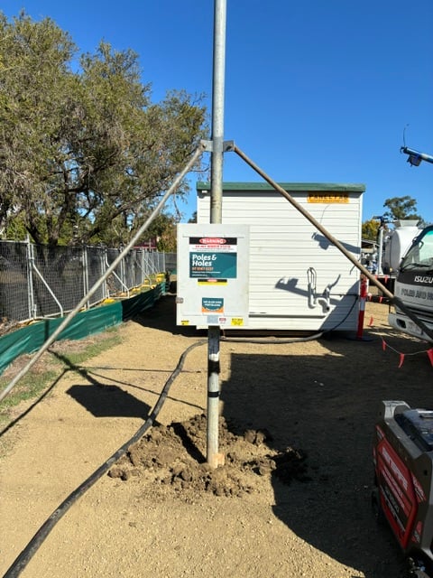 A Poles and Holes temporary builder's power pole installed with metal stays on a South East Queensland construction site