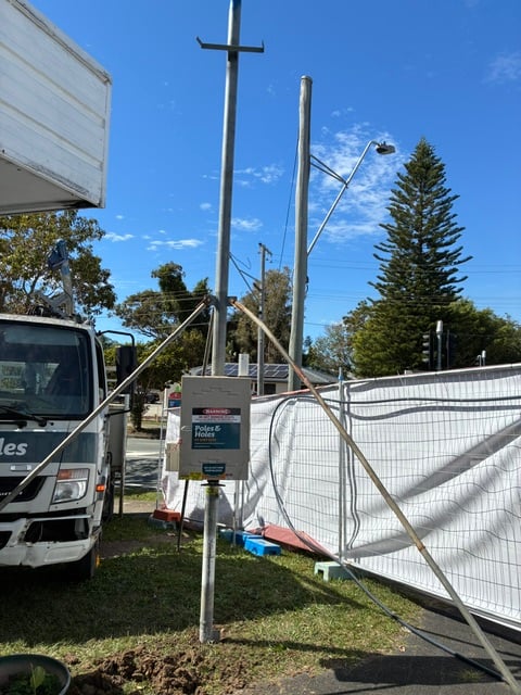 A Poles and Holes temporary builder's power pole installed with metal stays on a South East Queensland construction site