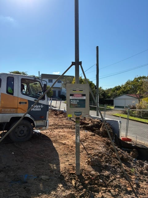 A Poles and Holes temporary builder's power pole installed with metal stays on a South East Queensland construction site