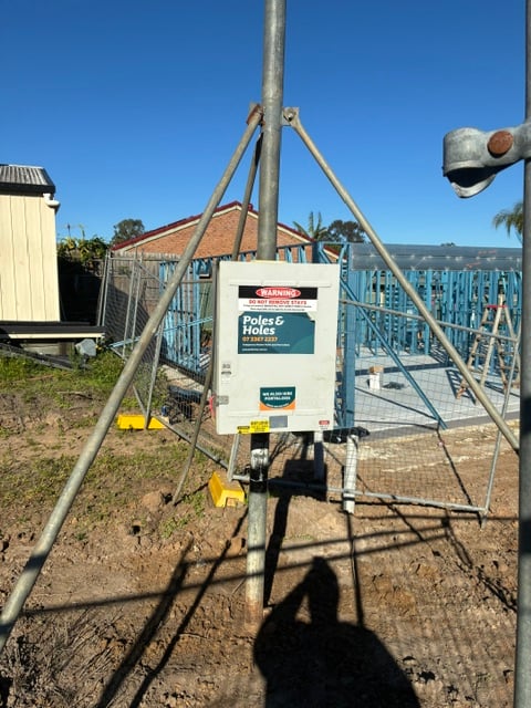 A Poles and Holes temporary builder's power pole installed with metal stays on a South East Queensland construction site