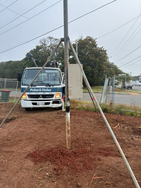A Poles and Holes temporary builder's power pole installed with metal stays on a South East Queensland construction site