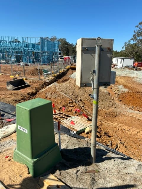 Underground temporary power connection: an Energex pillar and conduit in the trench beside the pole